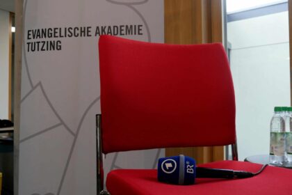 Mikrofon des Bayerischen Rundfunks liegt auf Stuhl eines Podiumsgasts