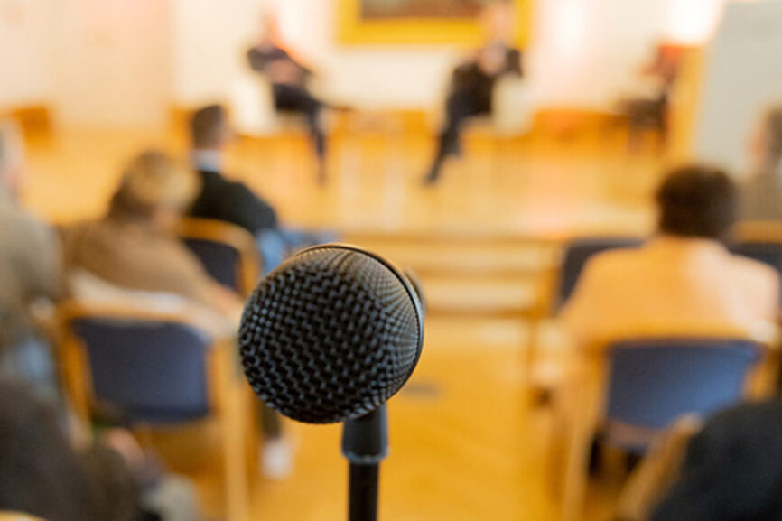 Mikrofon - im Hintergrund (unscharf) ein Podium. Szene aus einem Politischen Club der Evangelischen Akademie Tutzing