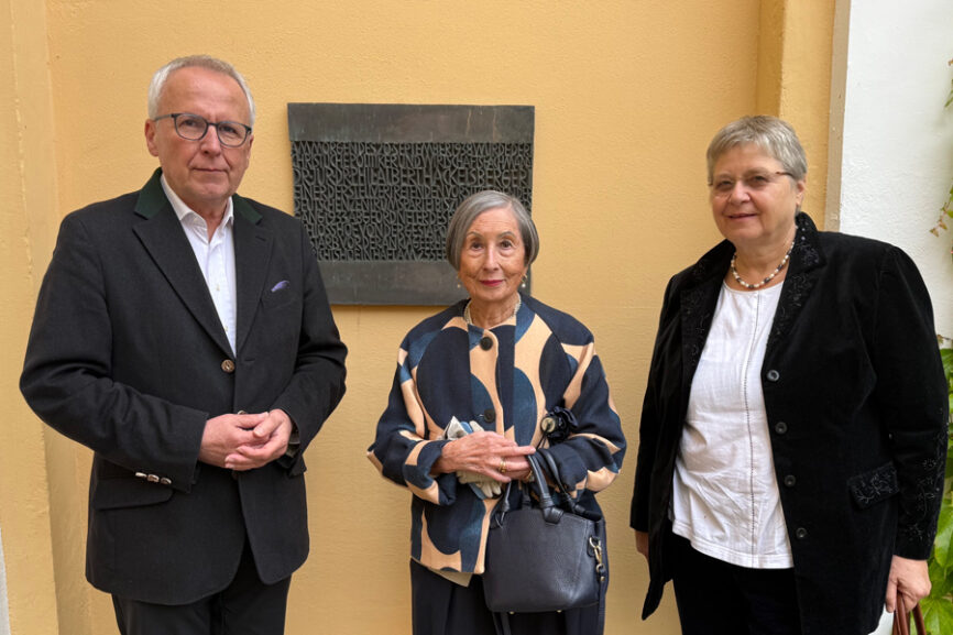 Udo Hahn, Dr. Min-Mi Hackelsberger-Lian und Edigna Hackelsberger vor der Gedenktafel des Bildhauers Fritz Koenig im Innenhof von Schloss Tutzing.